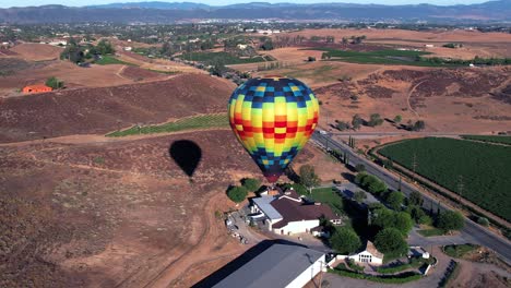 A-hot-air-balloon-rises-over-the-California-wine-country-landscape---aerial-drone-footage-with-dynamic-motion