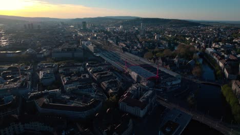 Stunning-aerial-drone-view-of-Zurich-cityscape,-flying-above-train-station
