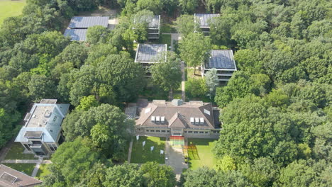 Aerial-of-convention-center-with-small-office-buildings-with-solar-panels-on-rooftop-in-forest