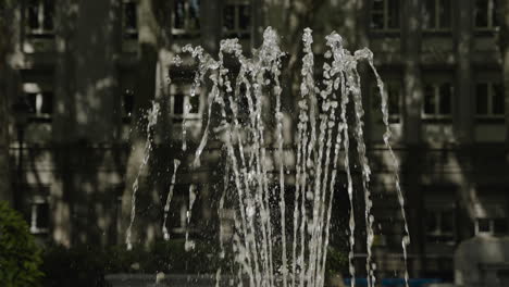 Wasser-Plätschert-Im-Brunnen-Vor-Dem-Hintergrund-Der-Stadt-In-Madrid,-Zeitlupenansicht