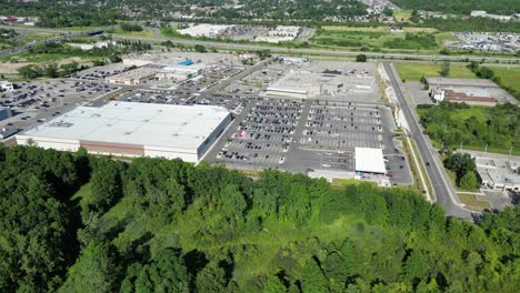Costco-wholesale-warehouse-parking-lot-aerial-with-gas-station-near-forest