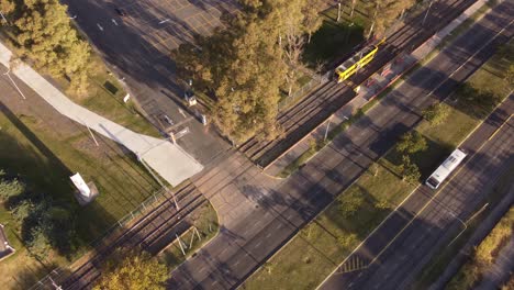 Aerial-view-orbiting-moving-yellow-streetcar-on-track