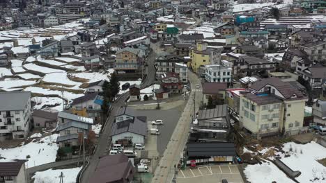 Antena-De-Arriba-Hacia-Abajo-De-Una-Ciudad-De-Esquí-En-Nagano-Japón-Con-Carreteras-Vacías-Durante-El-Invierno