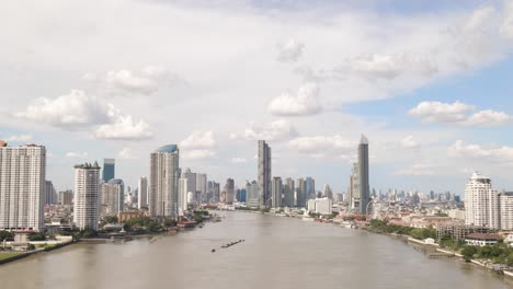 Aerial-Panorama-view-of-Bangkok-Skyline-through-Chao-Phraya-river-Riverbank,-Thailand