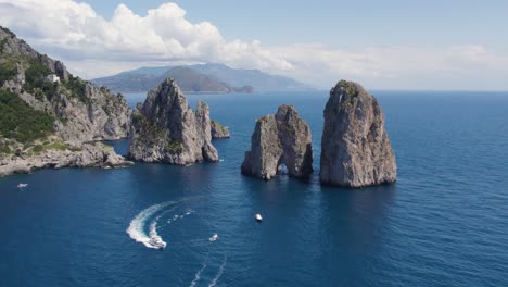 Luxury-Yacht-Boats-by-Faraglioni-Rocks-off-Island-of-Capri,-Italy,-Aerial