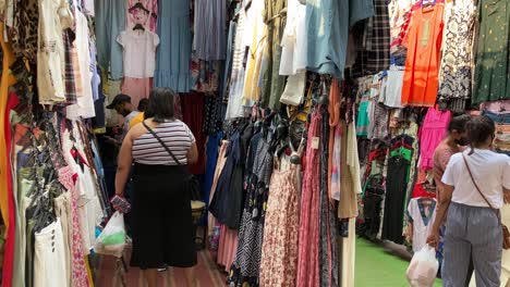 A-shopkeeper-shows-clothes-to-buyers-at-a-local-garment-market