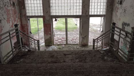 Slider-Footage-from-the-Top-of-the-Stairway-in-an-Abandoned-High-School-Front-Entrance