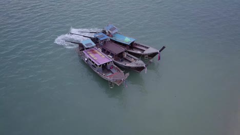 Three-Traditional-Thai-Boats-Floating-In-The-Sea-Near-The-Shore-In-Phuket,-Thailand