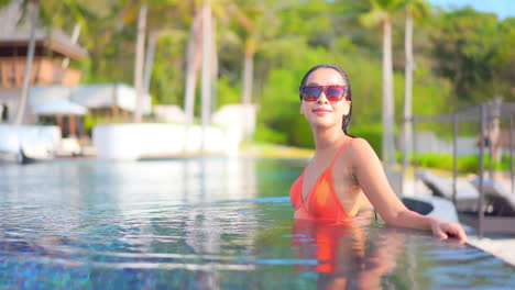 Wunderschöne-Sexy-Exotische-Frau-Im-Schwimmbad-Eines-Tropischen-Resorts,-Die-An-Einem-Sonnigen-Tag-Genießt