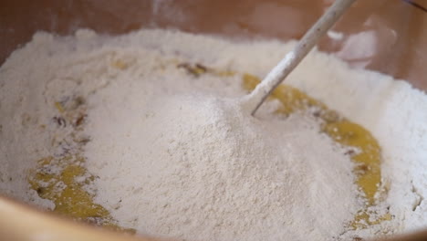 Close-up-shot-of-person-adding-flour-to-biscuit-dough-into-bowl