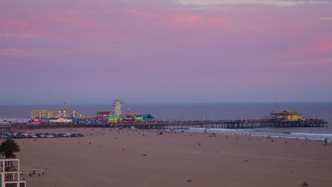 Strandbesucher-Kommen-Bei-Sonnenuntergang-Voll-Auf-Ihre-Kosten,-Wenn-Die-Lichter-Am-Santa-Monica-Pier-Zu-Leuchten-Beginnen-Und-Die-Menschenmenge-Hereinströmt