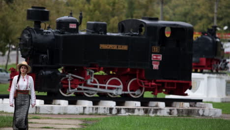 Romanian-girl-walks-in-outdor-steam-locomotives-museum-in-Resita,-Romania-2