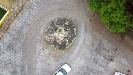 top-down-drone-shot-of-roundabout-with-car-and-motorcycle-drive-by