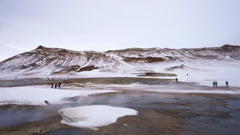 Tourists-visiting-Myvatn-Geothermal-Area-with-rising-steam-on-Iceland,Europe---wide-shot