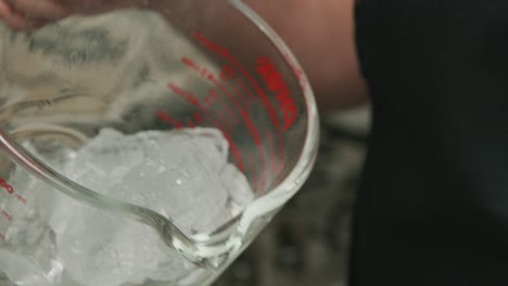 Chef-takes-out-ice-cubes-from-measuring-cup
