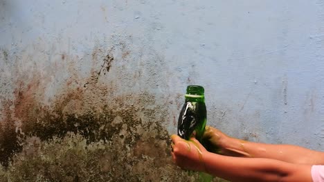hand-squeeze-the-bottle-filled-with-green-liquid-until-it-spurts-in-slow-motion