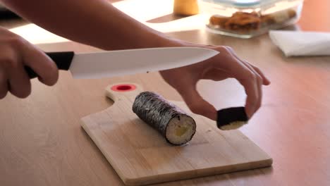 In-Der-Küche-Eine-Sushi-Rolle-Zerschneiden