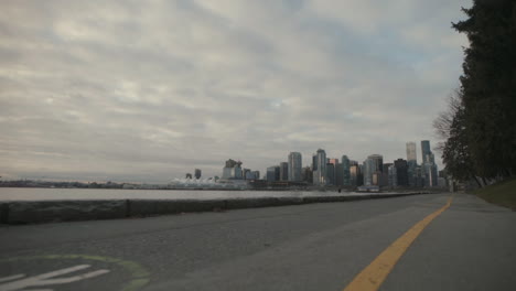 Weitwinkelaufnahme-Des-Seawall-Trail-Mit-Der-Skyline-Von-Vancouver-Im-Hintergrund,-Morgen,-Zeitlupe