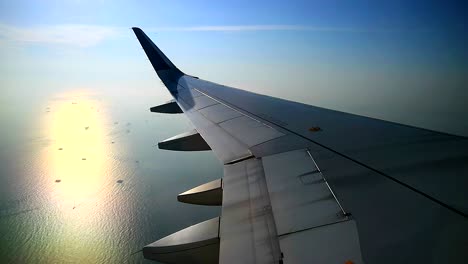 morning-sun-reflection-on-ocean,-view-from-airplane-windows