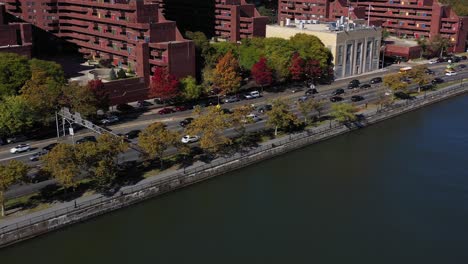 Light-drone-zoom-of-FDR-Drive-in-Harlem,-Manhattan,-NYC-along-the-Harlem-River-in-bright-midday-sun