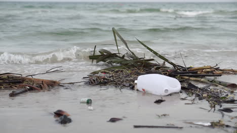 Botella-De-Plástico-Y-Residuos-Dejados-En-La-Arena-De-La-Playa-Contaminando-El-Mar