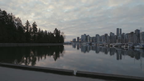 Wide-camera-roll-shot-of-a-Stanley-park-trail-and-boats-in-morning-marina,-Vancouver-West-End,-Slowmotion