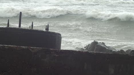Big-waves-hitting-the-abandoned-concrete-coast-defense-building-ruins-in-stormy-weather
