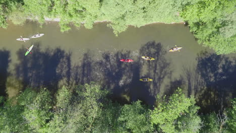AERIAL-SLOMO:-Topshot-of-kayaks-floating-down-a-river-on-a-sunny-day