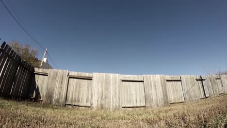 TIME-LAPSE---Shadows-slowly-across-a-wooden-fence-in-a-yard-on-a-clean-sunny-day