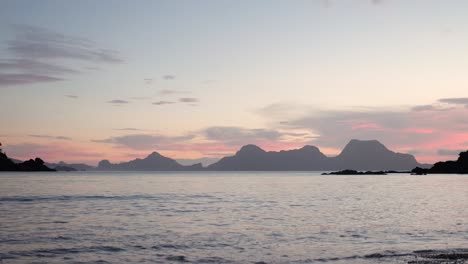 Zeitlupenaufnahme-Eines-Farbenfrohen-Sonnenuntergangshimmels-Hinter-Kalksteinfelsen-Im-Meer-In-Asien,-Vom-Strand-Aus-Gesehen
