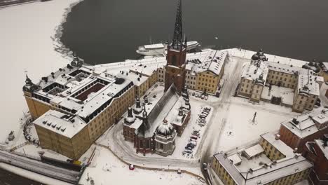 Zoom-out-cinematic-aerial-view-of-historic-Riddarholmen-church-located-in-Old-Town-of-Stockholm,-Sweden