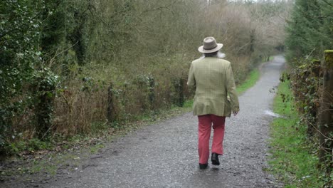 Elderly-man-with-beard-walking-down-stone-path