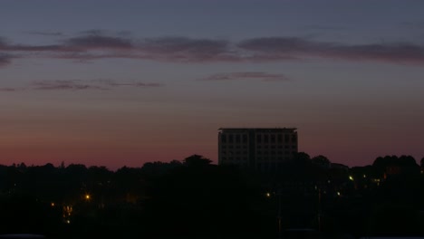 Dawn-and-dusk-timelapse-lasting-for-a-quarter-of-a-minute-of-a-large-office-building-in-a-suburban-area-of-England
