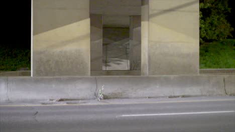 Cars-drive-by-in-the-late-evening-under-an-underpass-in-slow-motion-with-a-view-from-the-side