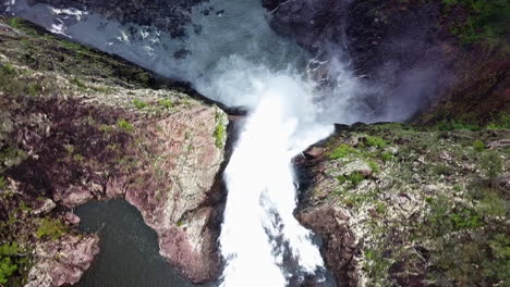 Drone-looking-straight-down-while-flying-over-edge-of-huge-waterfall