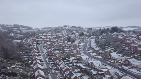 High-sideways-tracking-drone-shot-of-snowy-Exeter-subburbs