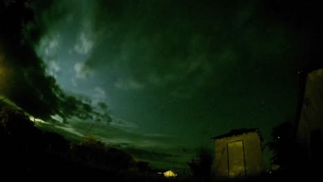 NIGHT-LAPSE---Stars-and-clouds-view-in-a-field-with-trees-and-little-shack-near-by