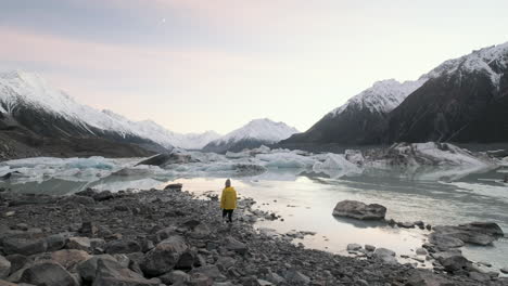 Mujer-Caminando-Hasta-El-Borde-Del-Lago-Glacial-Tasman-En-La-Isla-Sur-De-Nueva-Zelanda