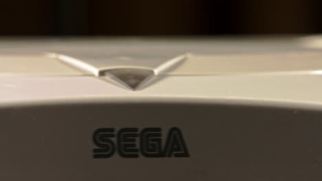 Consola-Y-Controlador-Sega-Dreamcast-Con-Enfoque-En-El-Logotipo-Y-Deslizamiento-Del-Joystick-Hacia-La-Izquierda