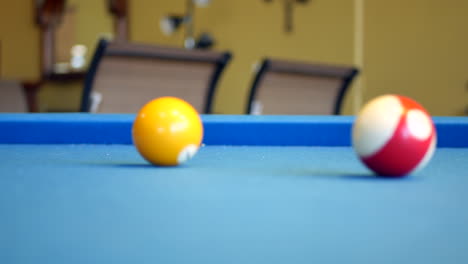 Pool-balls-rolling-around-on-blue-felt-billiards-table