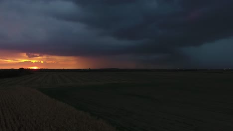 Flug-über-Ein-Feld-Bei-Sonnenuntergang-Während-Eines-Gewitters