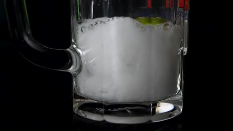 Close-up-shot-of-soda-which-get-filled-in-a-glas-with-lime-and-ice-cubes-in-slow-motion