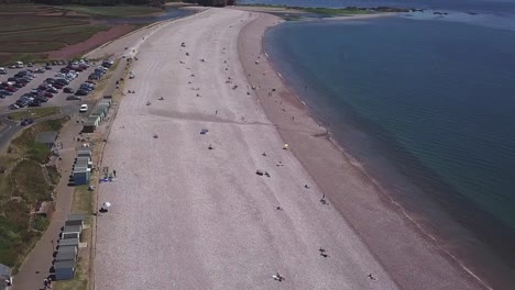 Flying-over-Budleigh-beach-in-southwest-England-where-people-are-enjoying-a-day-outside-sitting-at-the-pebble-beach