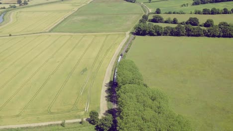 Große-Luftaufnahme-Eines-Dampfzuges,-Der-Den-Bahnhof-Bodiam,-East-Sussex,-England,-Verlässt