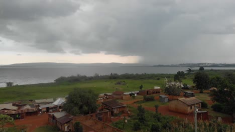 Luftaufnahme-über-Einem-Afrikanischen-Dorf-Mit-Einem-Großen-Tropischen-Sturm-über-Dem-Victoriasee