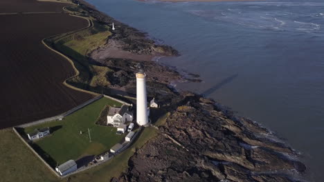 Aerial-footage-of-Scurdie-Ness-lighthouse-in-Montrose-on-a-sunny-day,-Angus,-Scotland