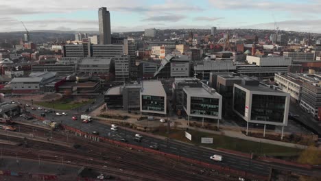 Drone-shot-above-the-city-of-Sheffield,-panning-over-the-Train-Station,-Sheffield-Hallam,-Park-Hill-and-more