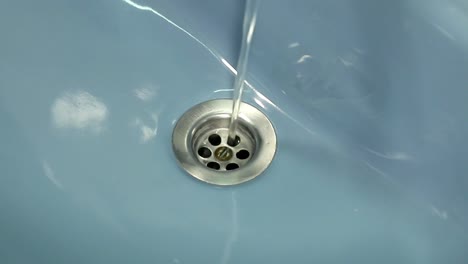 Clear-fresh-water-pouring-down-the-drain-in-the-bathroom