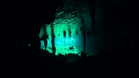Scuba-divers-below-cenote-swimmers