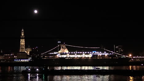 boat-passing-under-a-full-moon-at-the-Antwerp-skyline